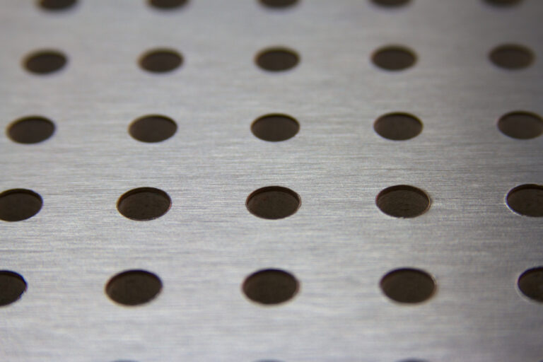 Grey metal perforated background close up